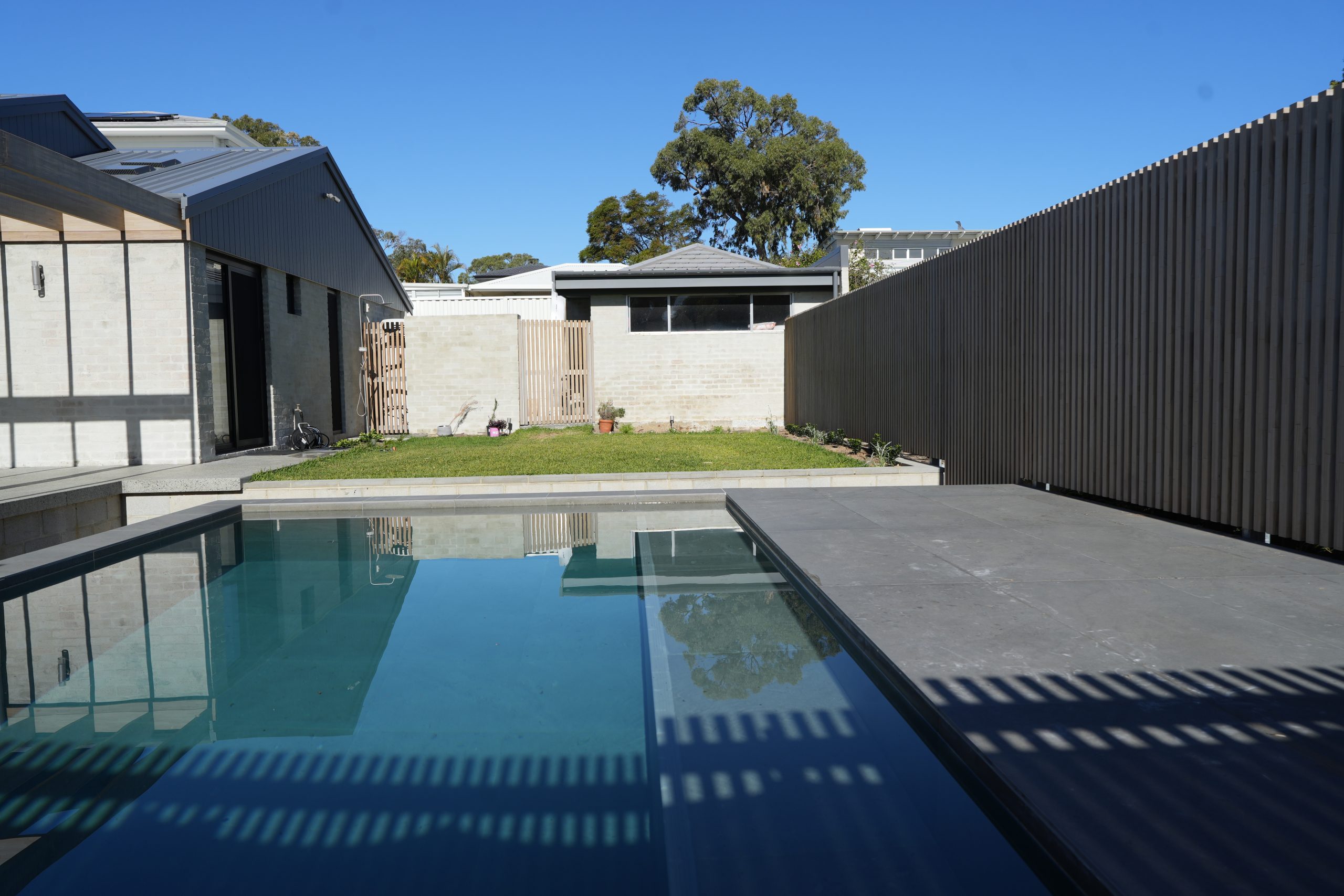 Swimming pool, lawn and rear of the home at the Gwelup renovation by Skytree Homes