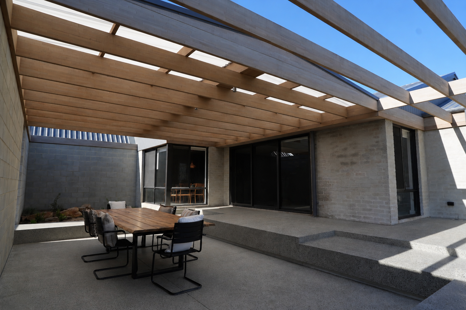 Covered alfresco with timber pergola beams and outdoor dining at the Gwelup renovation by Skytree Homes