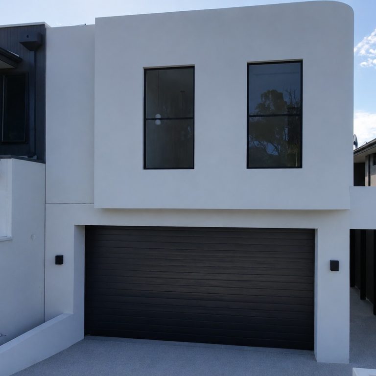 Front of the two-storey Melville home by Skytree Homes, with white render and a black garage door